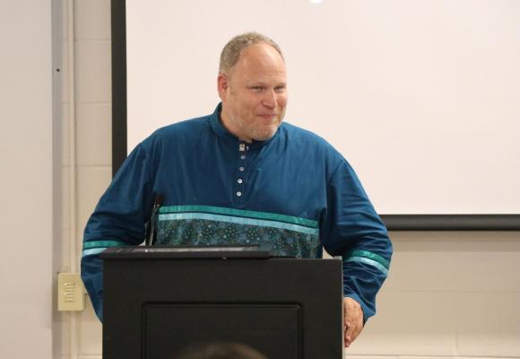 STEAM teacher Nathan Rowbottom stands at a podium