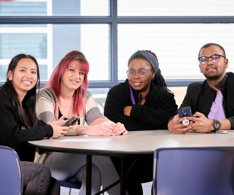 four students sitting at table